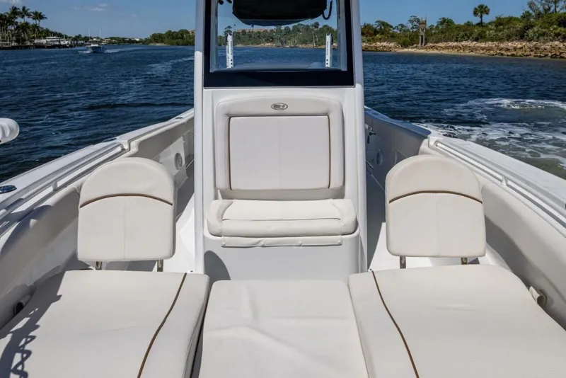 Slide: The Image of 2022 Sea Hunt Ultra 265 SE boat interior with white seating on a sunny day. - 6