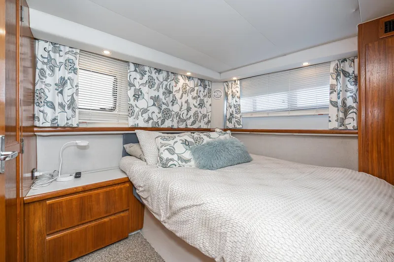 Slide: The Image of Cozy bedroom in 1993 Carver 350 Aft Cabin Motor Yacht with floral curtains and wood accents. - 10