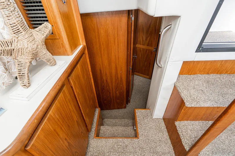 Slide: The Image of Interior of 1993 Carver 350 Aft Cabin Motor Yacht with wooden cabinetry and carpeted stairs. - 11