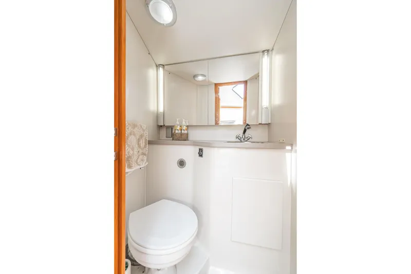 Slide: The Image of Compact bathroom in 1993 Carver 350 Aft Cabin Motor Yacht, featuring toilet and sink. - 13