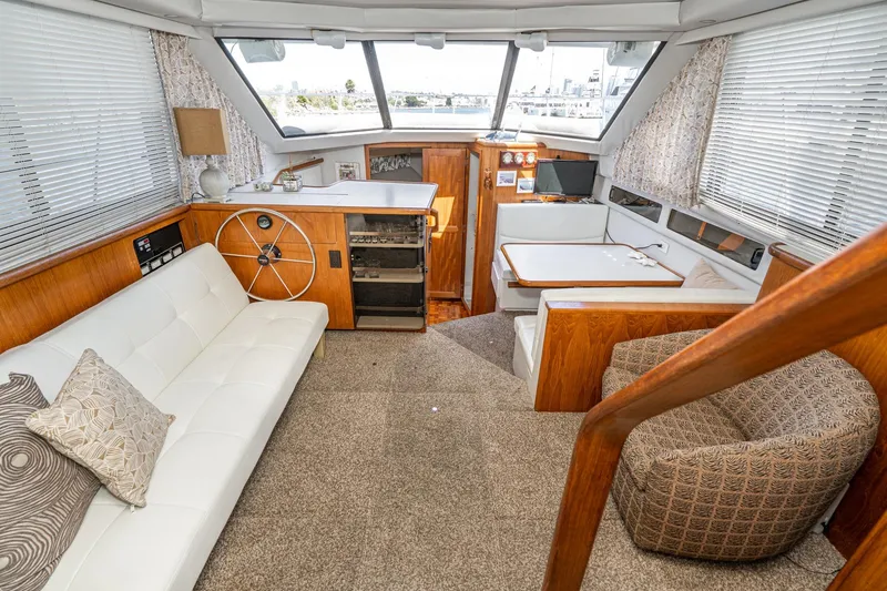 Slide: The Image of 1993 Carver 350 Aft Cabin Motor Yacht interior with cozy seating and helm station. - 5