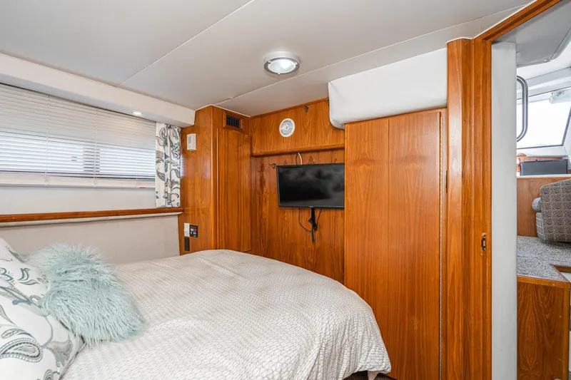Slide: The Image of Cozy bedroom in 1993 Carver 350 Aft Cabin Motor Yacht with wood paneling and TV. - 9