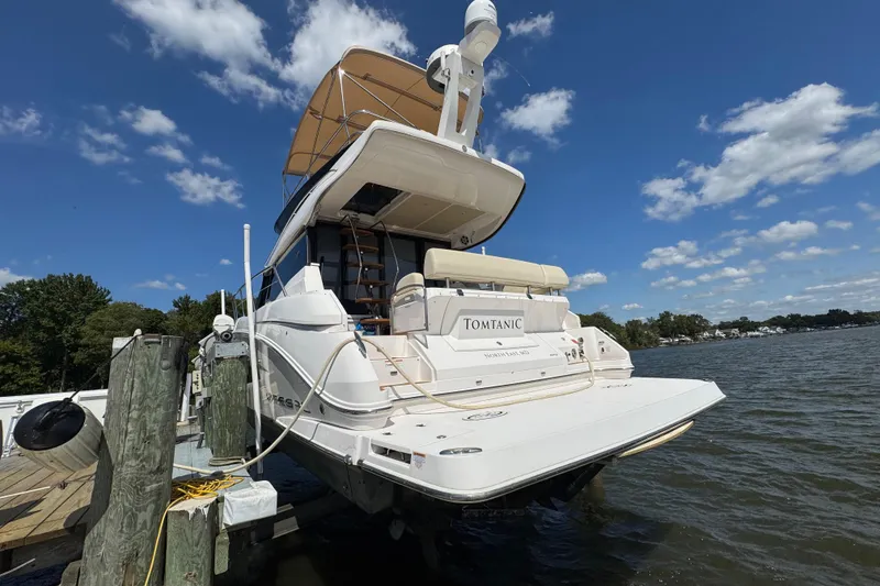 Slide: The Image of 2019 Regal 42 Fly yacht docked, featuring spacious deck and elegant design under blue sky. - 12