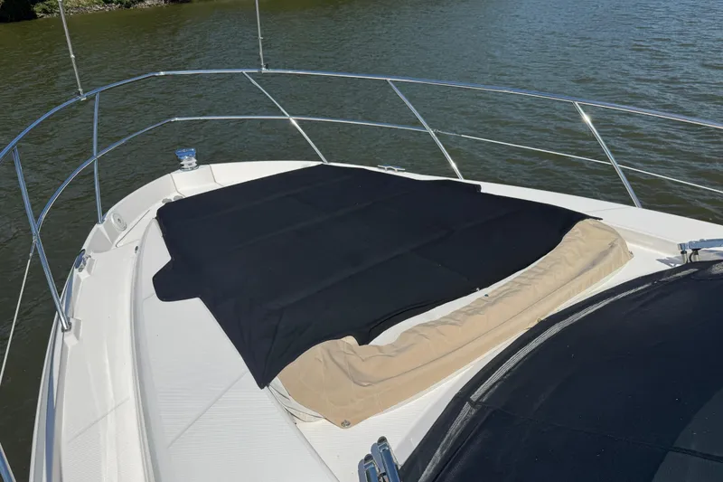Slide: The Image of 2019 Regal 42 Fly yacht bow with sunpad cover on calm water. - 15