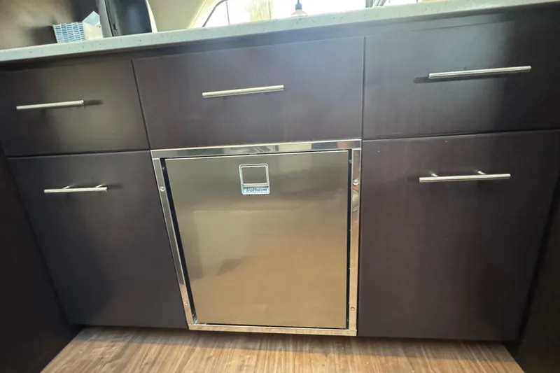 Slide: The Image of Dark wood cabinetry with stainless steel fridge in 2019 Regal 42 Fly yacht interior. - 36