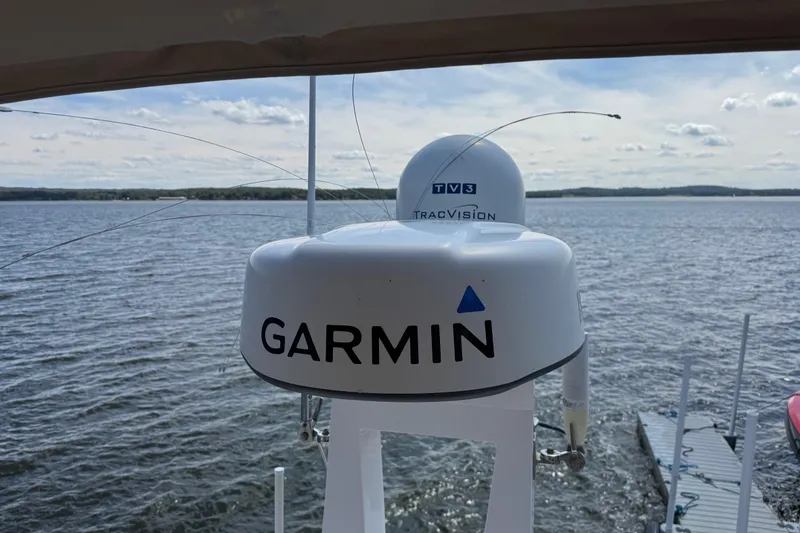 Slide: The Image of Garmin and TracVision equipment on 2019 Regal 42 Fly yacht, overlooking serene water. - 43