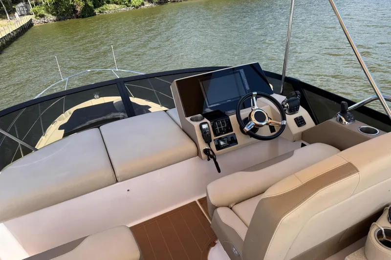 Slide: The Image of 2019 Regal 42 Fly yacht helm with modern controls and comfortable seating on the water. - 45