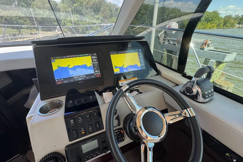 Slide: The Image of 2019 Regal 42 Fly yacht helm with navigation screens and steering wheel. - 51
