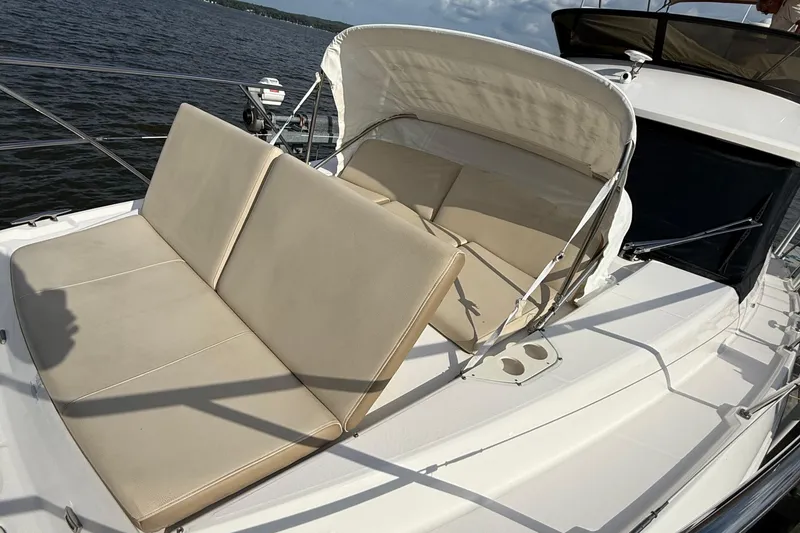 Slide: The Image of 2019 Regal 42 Fly yacht with beige seating on deck, overlooking water. - 8