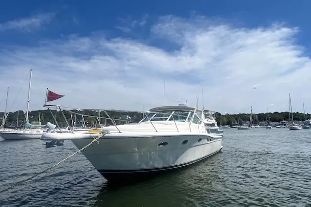 Slide: The Image of 1998 Tiara Yachts 3500 Open in a serene harbor setting under a clear blue sky. - 10