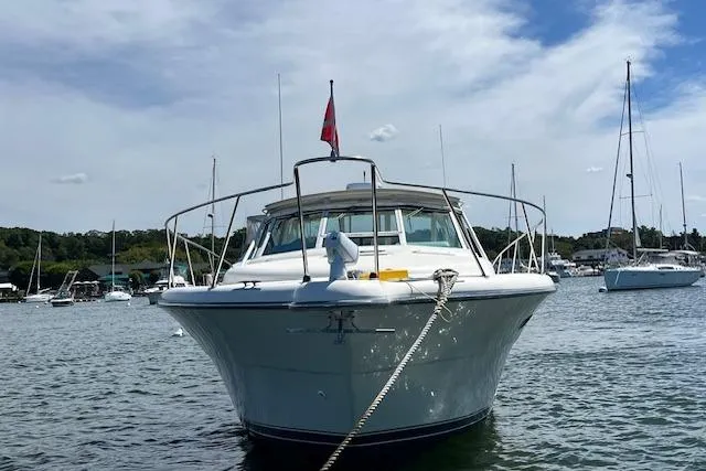 Slide: The Image of 1998 Tiara Yachts 3500 Open boat anchored in a scenic harbor. - 11