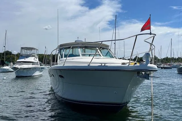 Slide: The Image of 1998 Tiara Yachts 3500 Open boat anchored in a marina under a clear sky. - 12