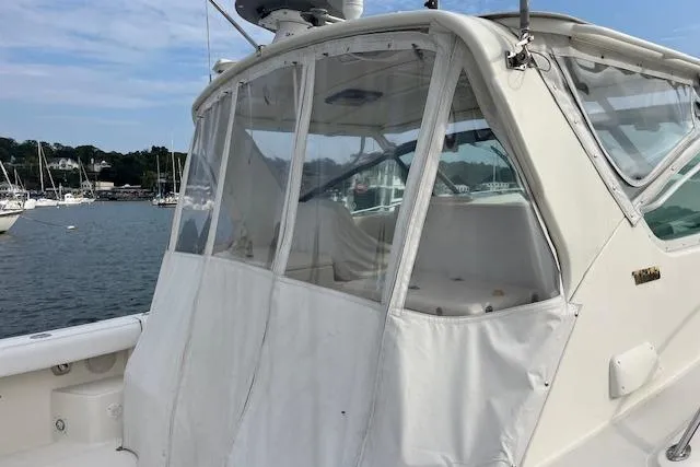 Slide: The Image of 1998 Tiara Yachts 3500 Open with clear enclosure, docked in a marina. - 17