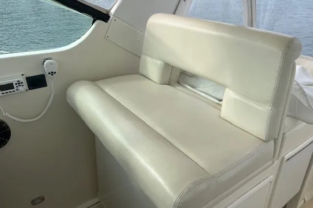 Slide: The Image of 1998 Tiara Yachts 3500 Open interior seating with white upholstery and control panel. - 20