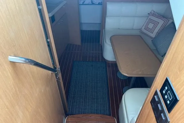 Slide: The Image of 1998 Tiara Yachts 3500 Open cabin interior with wood flooring and cushioned seating. - 28