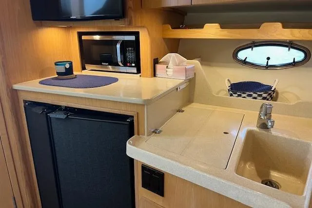 Slide: The Image of 1998 Tiara Yachts 3500 Open galley with sink, microwave, and mini fridge. - 35
