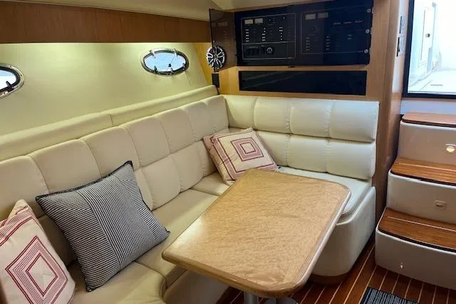 Slide: The Image of Interior of 1998 Tiara Yachts 3500 Open with beige seating and wooden table. - 36