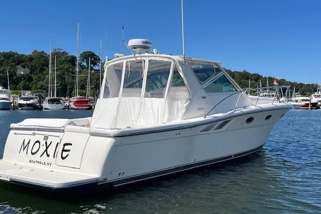 Slide: The Image of 1998 Tiara Yachts 3500 Open boat docked in a marina, clear blue sky. - 4