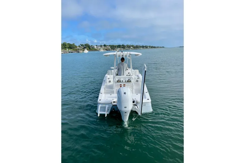 Slide: The Image of 2022 BlackJack 224 boat on calm water, rear view with clear sky. - 14