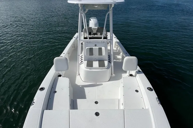 Slide: The Image of 2022 BlackJack 224 boat on water, showcasing spacious deck and seating. - 3