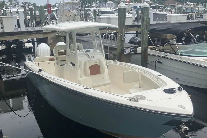 The Image of 2024 Cobia 280 Center Console boat docked at marina, showcasing sleek design and spacious deck. - 0