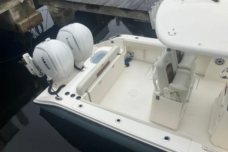 Slide: The Image of 2024 Cobia 280 Center Console boat with dual Yamaha engines at dock. - 1