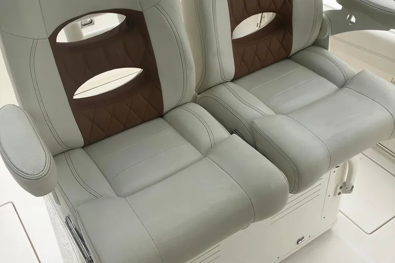 Slide: The Image of 2024 Cobia 280 Center Console boat seats with brown accents and armrests. - 15