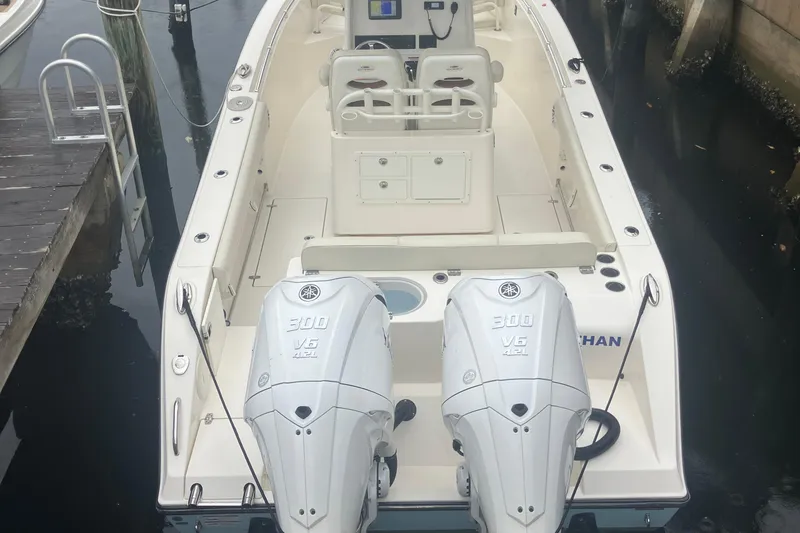 Slide: The Image of 2024 Cobia 280 Center Console boat with dual 300 V6 engines docked at marina. - 7