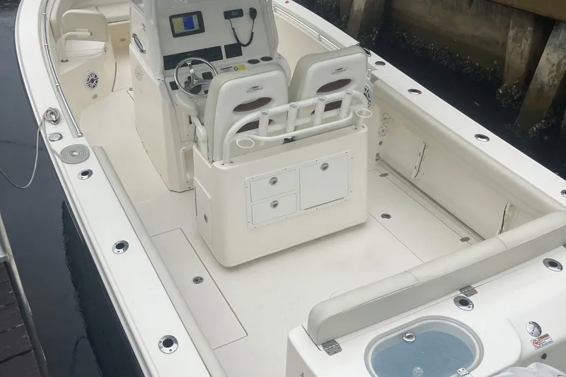 Slide: The Image of 2024 Cobia 280 Center Console boat interior with helm, seating, and storage compartments. - 8