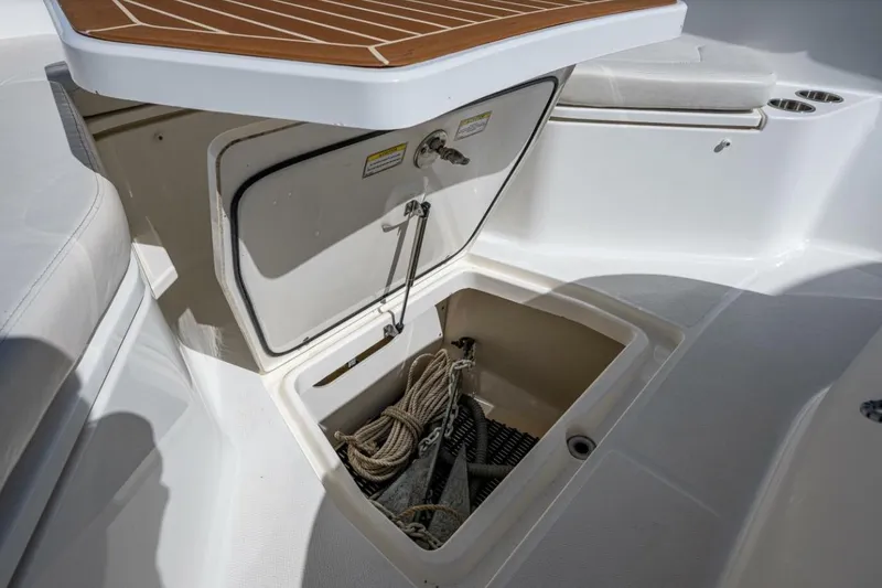 Slide: The Image of 2011 Boston Whaler 370 Outrage anchor storage compartment with rope and anchor visible. - 10