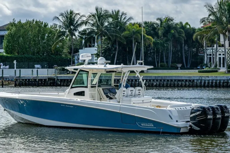Slide: The Image of 2011 Boston Whaler 370 Outrage boat on water, surrounded by palm trees and waterfront homes. - 15