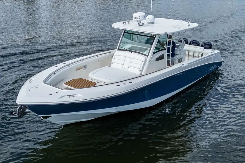 Slide: The Image of 2011 Boston Whaler 370 Outrage boat on calm water, featuring sleek design and spacious deck. - 18