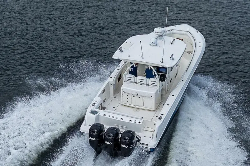 Slide: The Image of 2011 Boston Whaler 370 Outrage cruising on water with triple engines. - 3