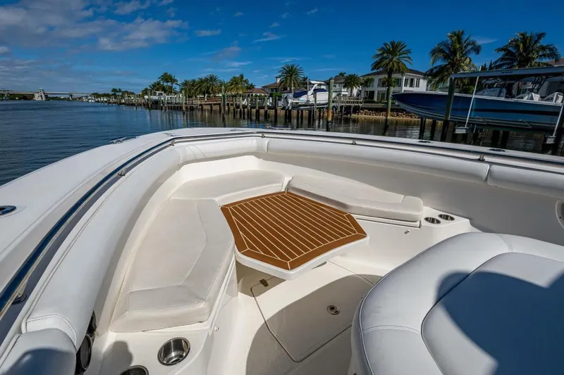 Slide: The Image of Boston Whaler 370 Outrage 2011 boat interior with seating and table, docked by palm trees. - 9