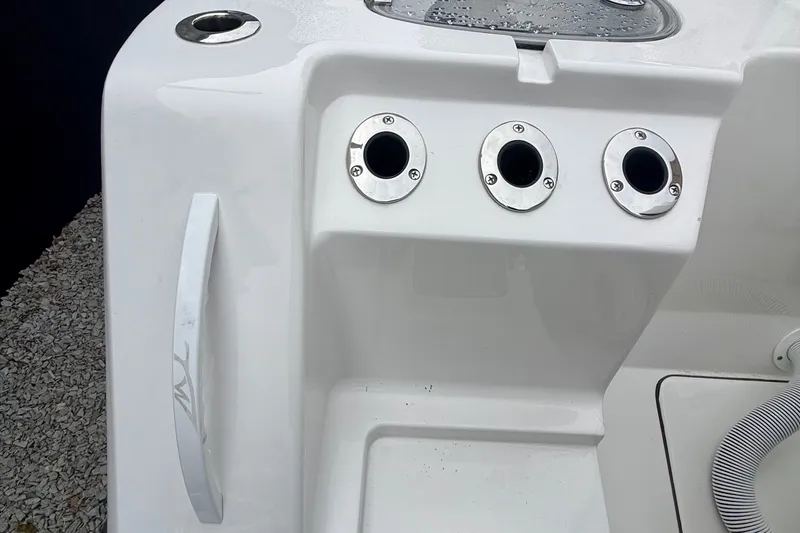 Slide: The Image of 2026 Tidewater 302 CC Adventure boat displayed indoors with large American flag backdrop. - 11