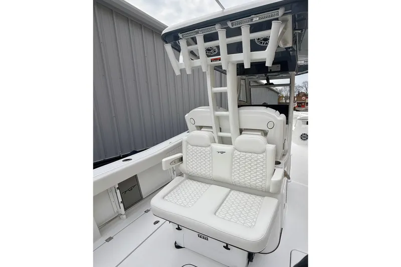 Slide: The Image of 2026 Tidewater 302 CC Adventure boat interior with white seating and rod holders. - 16