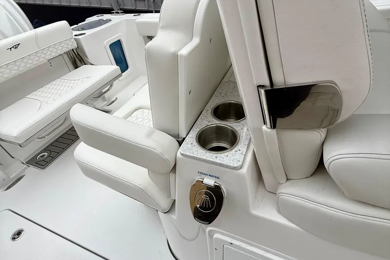 Slide: The Image of 2026 Tidewater 302 CC Adventure boat interior with white cushioned seating and rod holders. - 17