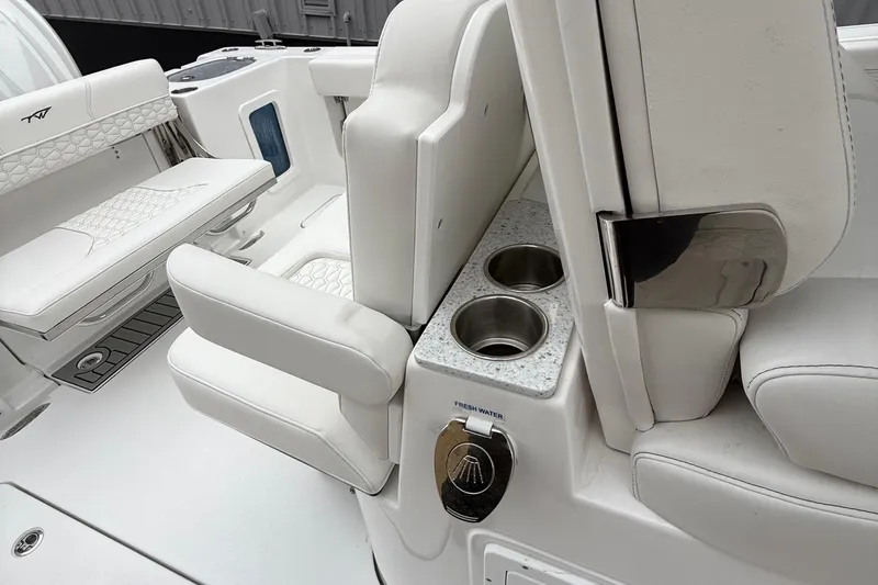 Slide: The Image of 2026 Tidewater 302 CC Adventure boat interior with white seating and cup holders. - 18