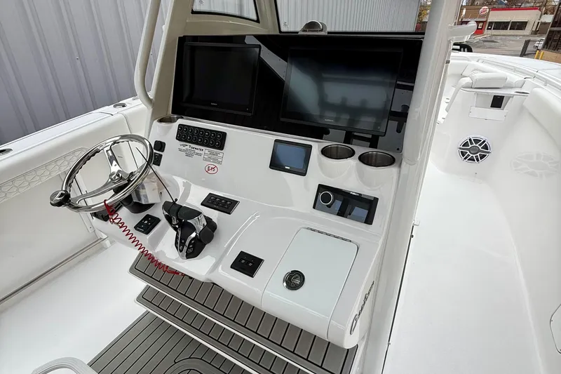 Slide: The Image of 2026 Tidewater 302 CC Adventure boat interior with white seating and cup holders. - 19