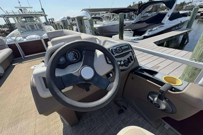 Slide: The Image of 2018 Princecraft Vectra 25 boat dashboard with steering wheel and controls at marina. - 5