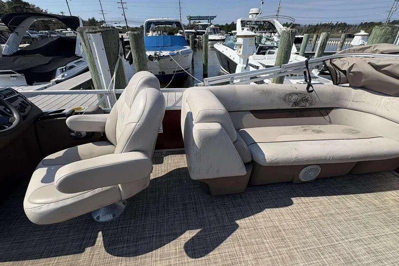 Slide: The Image of 2018 Princecraft Vectra 25 boat interior with beige seating at a marina. - 6