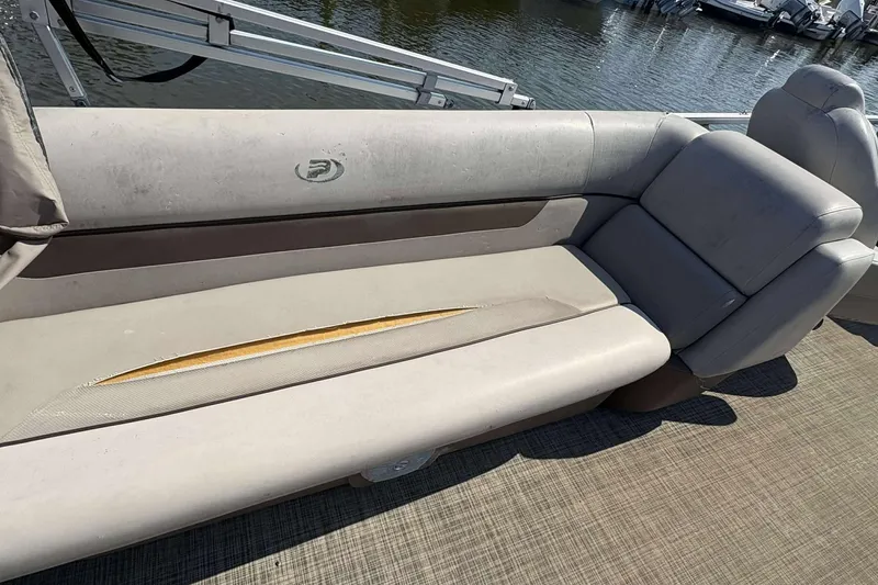 Slide: The Image of 2018 Princecraft Vectra 25 boat seat with visible wear and tear, docked by the water. - 8