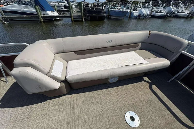 Slide: The Image of 2018 Princecraft Vectra 25 pontoon boat with beige seating, docked at marina. - 9