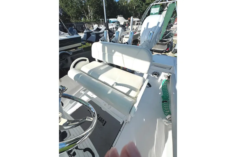 Slide: The Image of 2022 Everglades 243 Center Console boat interior with white seating and steering wheel. - 12