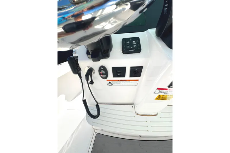 Slide: The Image of Control panel of 2022 Everglades 243 Center Console boat, featuring steering wheel and electronic controls. - 23