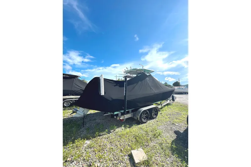 Slide: The Image of 2022 Everglades 243 Center Console boat covered on trailer under clear blue sky. - 31