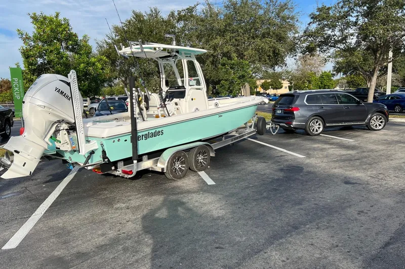 Slide: The Image of 2022 Everglades 243 Center Console boat on trailer, parked in a lot, hitched to a vehicle. - 5