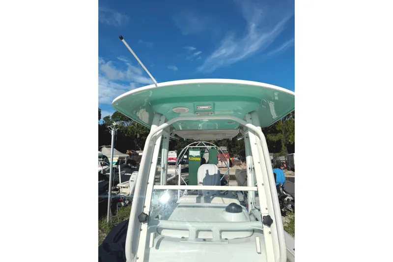 Slide: The Image of 2022 Everglades 243 Center Console boat with T-top under a clear blue sky. - 7