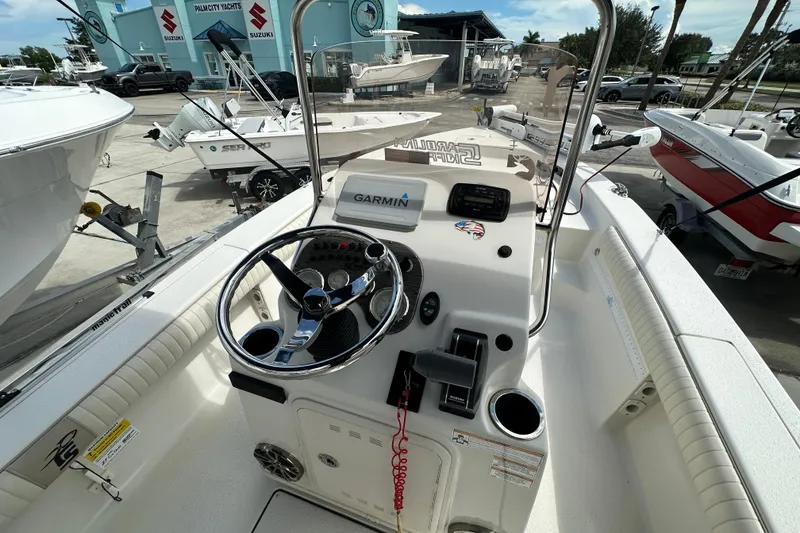 Slide: The Image of 2017 Carolina Skiff 21 Sea Skiff boat interior with steering wheel and Garmin navigation system. - 6