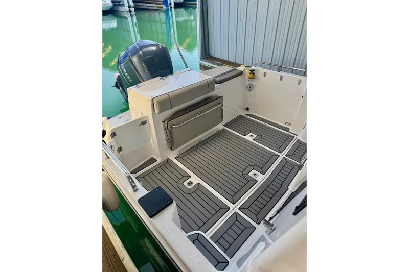 Slide: The Image of 2021 Cutwater C-24 Coupe boat interior with cushioned seating and outboard motor. - 11